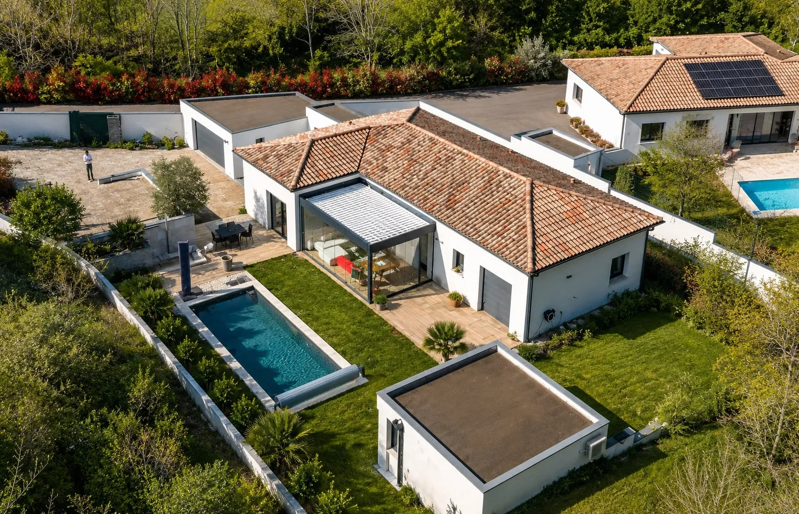 La véranda vitrée de la maison de Montrabé, ouverte sur la terrasse et la piscine.