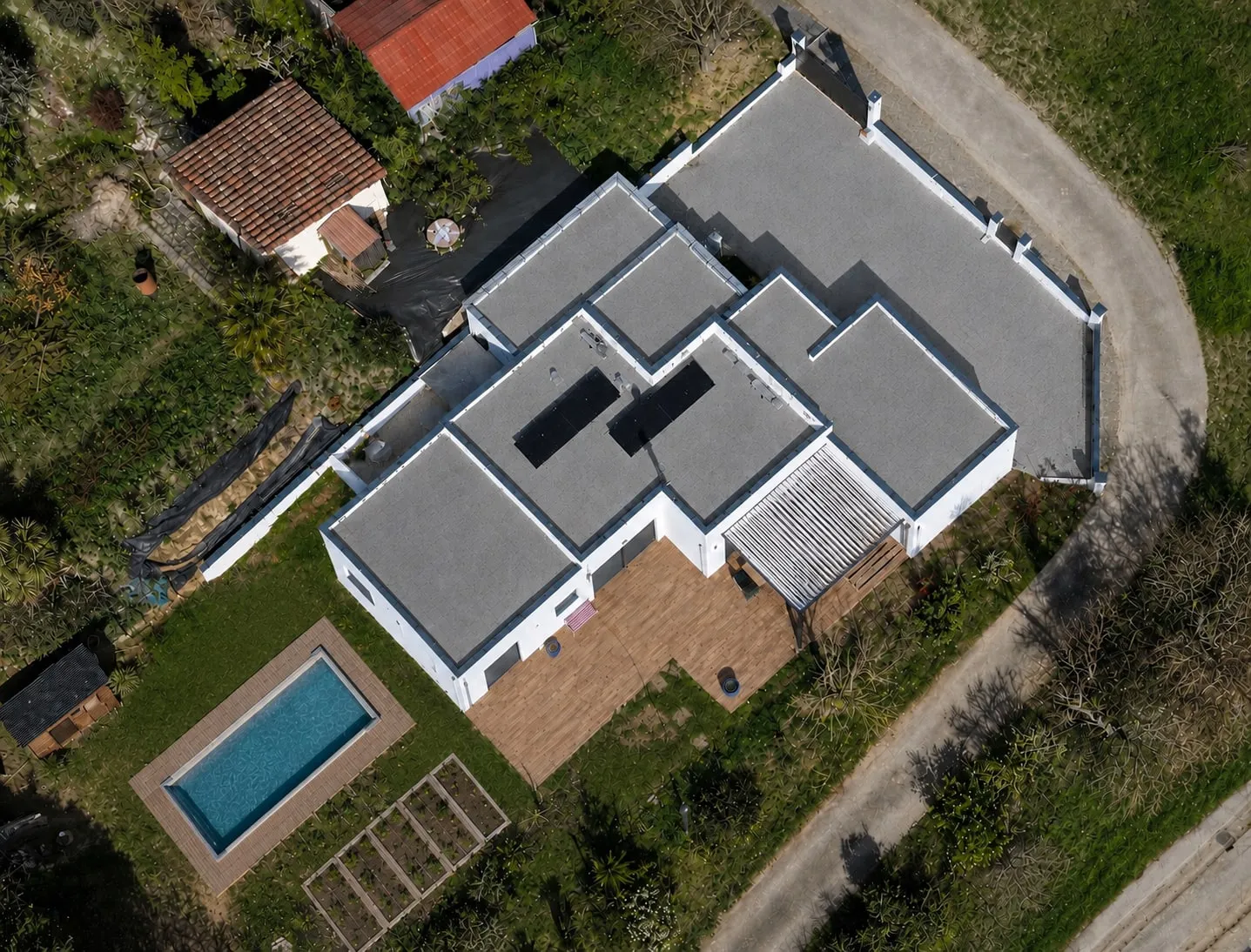 Vue zénithale de la maison à toiture-terrasse de Venerque et de son bassin.